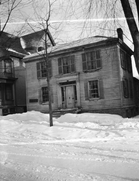 A wintery view of the E. Roth house on 619 West Doty Street. A colonial style house, with double walk(?) inside. Formerly owned by the Westerfield(?) family.
