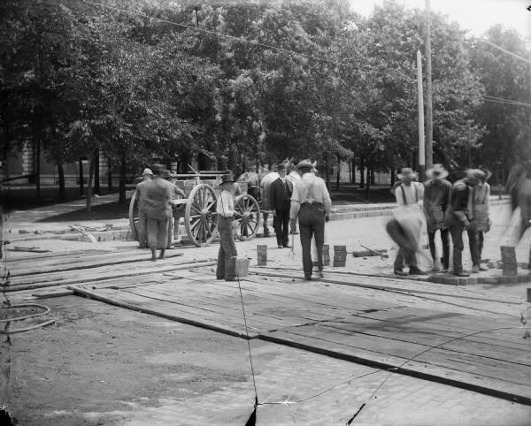 Men working on a wood block road.