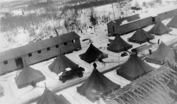 Elevated view of Camp Beaver showing tents, a truck and snow.