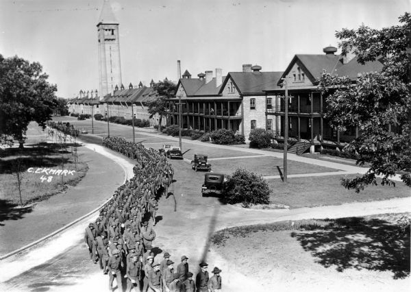 Elevated view of men in formation, probably the Civilian Conservation Corps (CCC) Company 1604, marching through the grounds of Fort Sheridan.