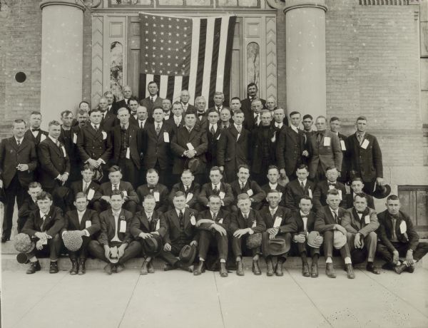 Group portrait of World War I draftees dressed in suits, posing in front of the Court House.