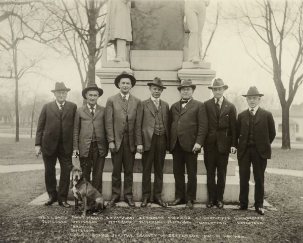 Group portrait of the Jefferson County Draft Board. From left to right are Dr. G.L. Smith, John Welch, E.T. Hayhurst, G.J. Kispert, F.W. Hoard, O.C. Werthheimer, and H. Mulberger. The dog in front of John Welch is listed as "Brownie".