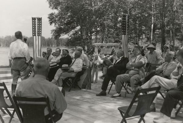 Dedication ceremony for the dam on the St. Croix River that is now part of the Gordon Dam County Park.  Construction on this dam was begun as a WPA project in 1935.  1937 figures indicated that the dam affected the water level in 30 area lakes.  Among the dignitaries attending the ceremony are Wisconsin Adjutant General Ralph Immell (seated with crossed arms and saddle shoes), suggesting that an armory may have been part of the facility.