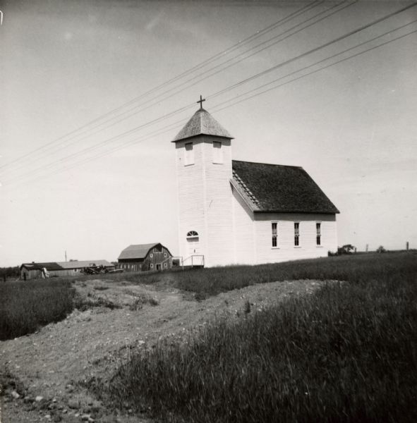 Exterior view of Suomi Synod Church. A farm is visible in the distance.