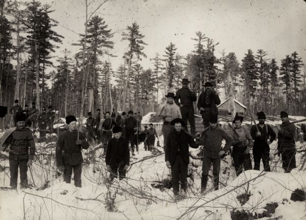 Logging crew posed in snow at a logging camp.
