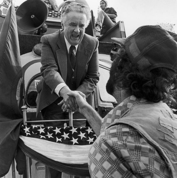 Campaigning for governor on the back of his "Red Vest Whistle-Stop Special" bus, Lee Sherman Dreyfus shakes hands with a supporter.