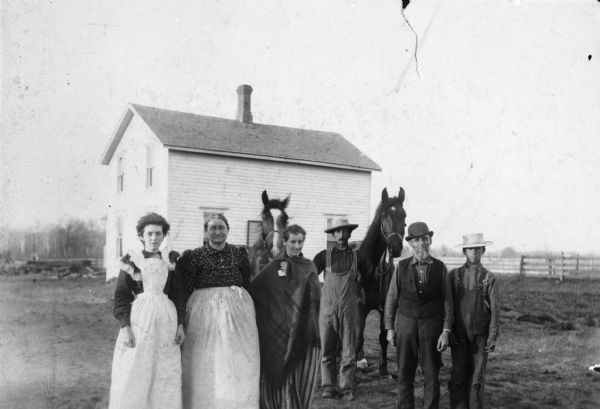 Members of the Davies and Thomas families pose with two horses at James E. Davies' farm on Highway A, west of K.