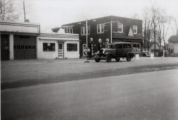 Droster Grocery and Filling Station at 1438 Sherman Avenue with a car at the pumps.