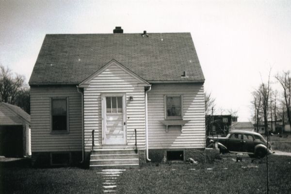 Exterior of the house at 1501 Hooker Avenue shortly after construction. An automobile is parked in the driveway. The house was built by Willard Droster.