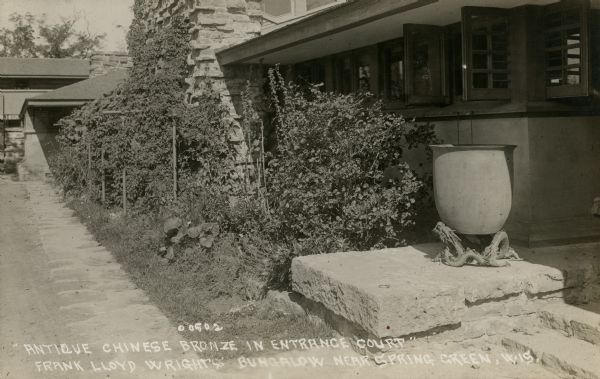 View of the entrance court of Taliesin, Frank Lloyd Wright's residence and studio, as it appeared after its completion in May of 1911 and before its partial destruction by fire in August of 1914. Taliesin is located in the vicinity of Spring Green, Wisconsin. Caption reads: "'Antique Chinese Bronze in Entrance Court'" and "Frank Lloyd Wrights' Bungalow near Spring Green, Wis."