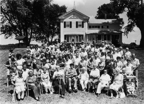 Large family gathered in front of house for a group portrait.