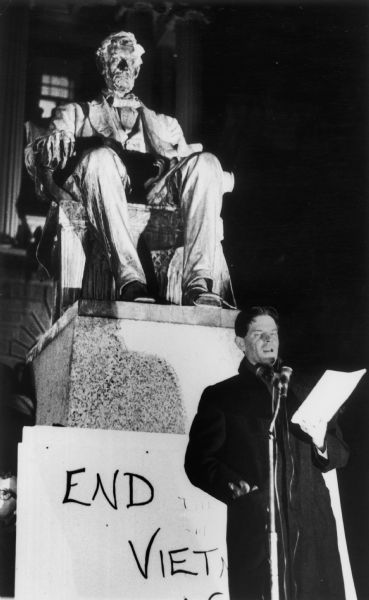 Standing near the Lincoln Statue on Bascom Hill at the University of Wisconsin-Madison, Historian Staughton Lynd speaks to a nighttime, anti-war demonstration on Bascom Hill. Lynd was one of the organizers of the National Coordinating Committee Against the War in Vietnam which was headquartered in Madison.