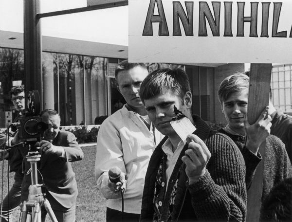 At a demonstration against the payment of taxes to support the war in Vietnam, a young man burns his check to the Internal Revenue Service. Probably in front of the IRS Office in Milwaukee.