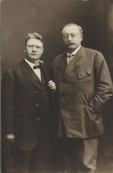 Three-quarter length formal studio portrait of Victor Berger and Emil Seidel.