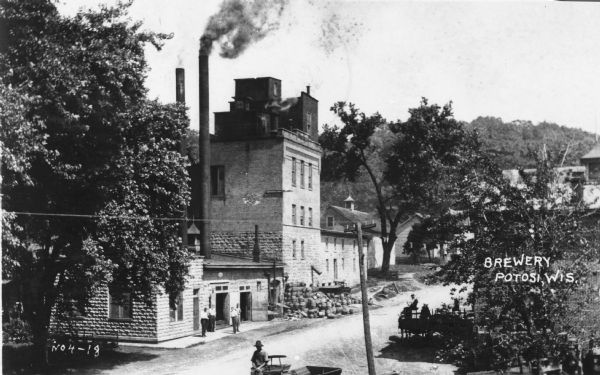 The Potosi Brewery. Men can be seen standing in front of the building, and driving horse-drawn vehicles.