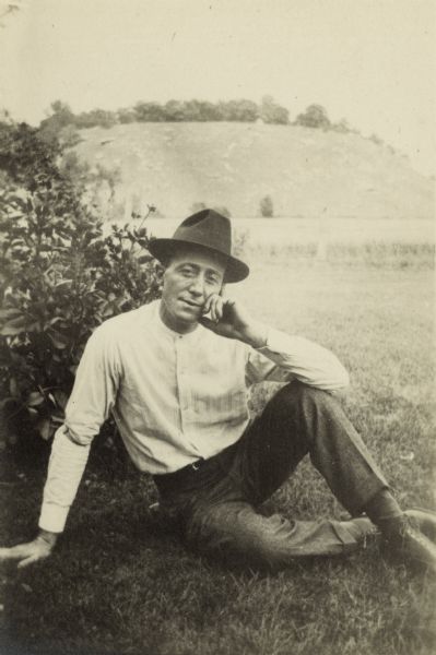 Casual portrait of photographer Matthew Witt seated at the foot of a ridge. It's likely that the image is a self-portrait produced by Witt himself.