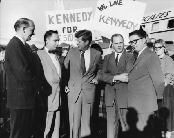Presidential candidate John F. Kennedy at the Madison airport with state Democratic leaders. To Kennedy's left are Governor Gaylord Nelson and state Democratic Party head Patrick J. Lucey. Ivan Nestingen, the mayor of Madison, is on the far right, and directly to Kennedy's right is Marvin Brickson, head of the Madison Federation of Labor.