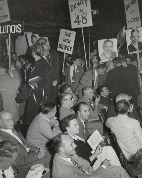 Group of people, many holding signs, at a presidential rally for Thomas Edmund Dewey.