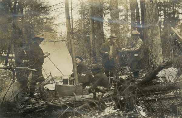 This view, captioned "Founders Day," shows several people camping in the woods. A tent is visible in the background.