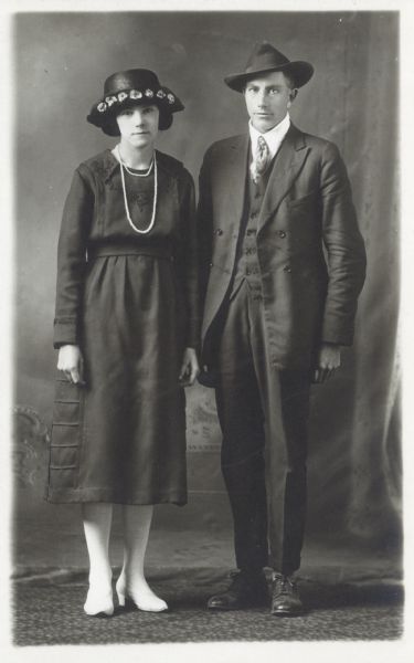 Photographic postcard of a studio portrait of Peter Maerz and Mrs. Susan Maerz Maier in front of a painted backdrop.