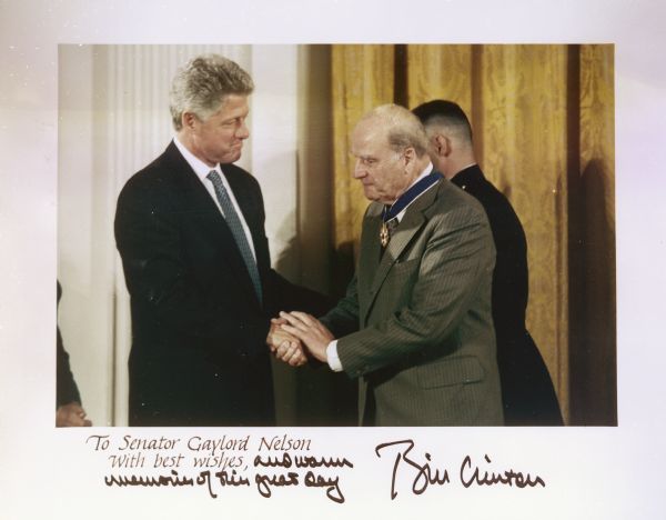 President Bill Clinton shakes hands with Nelson during the award ceremony. Clinton added a message and his signature at the bottom of the photograph.