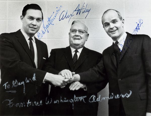 Bob Kastenmeier, Alex Wiley, and Bill Proxmire shaking hands. The photograph is inscribed and signed by all three politicians.