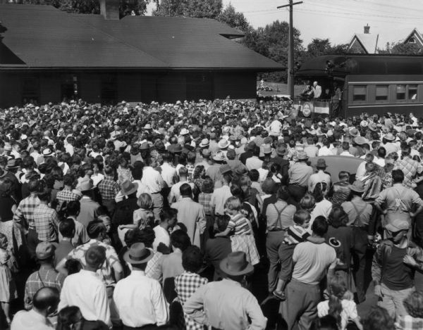 Elevated view of Dwight D. Eisenhower addressing a huge crowd from a train platform during his "Whistle-stop" election drive.