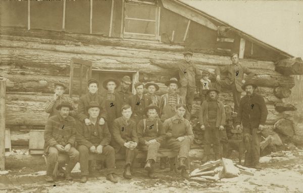 Shingle mill workers and a young boy pose in front of the men's bunk house. They are, as numbered on the photograph: 1. Jas Clark 2. Charles Elzea 3. Red Merrion 4. Claud Ketchum 5. Frank Baker 6. Arnold Becker 7. Milton Ritter 8. Christian Hanson 9. John Russell.