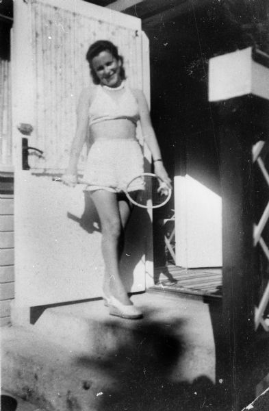 Pela Rosen Alpert, holding badminton racket, at a cottage belonging to the Schain family; Sweden.