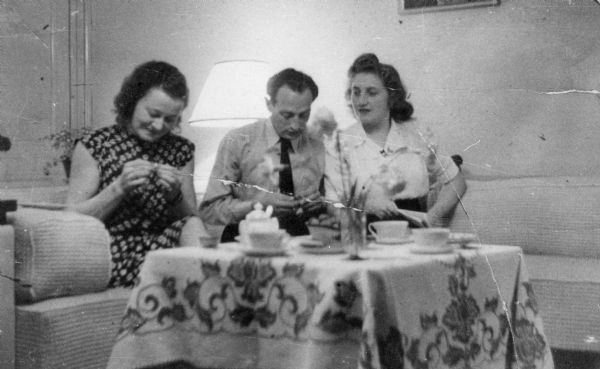 Left to right: friend Sophie, Josef and Flora van Brink Hony Bader (nee Melkman) in their home in Amsterdam. The tablecloth was made by Mrs. Bader and returned by her neighbors after the war.