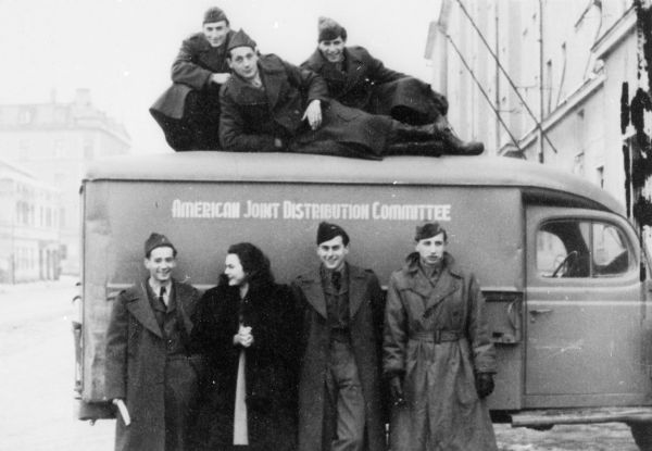Louis Koplin (far left, in front of truck) and friends. All the men are wearing uniforms of workers for the American Jewish Joint Distribution Committee; Munich.
