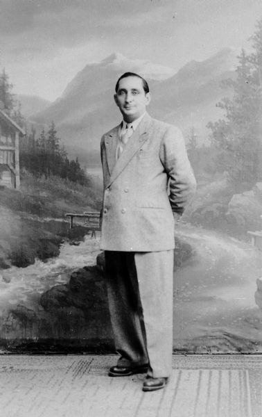 Portrait in front of a painted backdrop of Salvator Moshe in a custom-made suit, which he paid for with cigarettes, chocolate, and coffee; Weilheim, Germany.