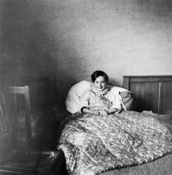 Portrait of Milo Weinschenker, the son of Chaim and Klara Weinschenker. He is sick, tucked into bed.
