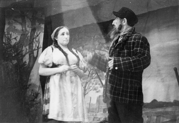 Portrait of a man and a woman performing in a theatrical production at a displaced persons camp; Germany.

Saul Sorrin was interviewed as part of the Wisconsin Survivors of the Holocaust Interviews project. Sorrin, born in New York in 1919, applied in 1940 for a position with the United Nations Relief and Rehabilitation Administration (UNRRA). He worked with Holocaust survivors as a supply officer for UNRAA team 560 at the Displaced Persons camp Neu Freimann Siedlung in Germany and later, at General Dwight D. Eisenhower's recommendation, Sorrin became the Area Director of the International Refugee Organization based at the Wolfratshausen DP camp in Bad Kissingen.

When asked about this image, Sorrin revealed, "Theater. That was a big diversion. Every camp had a theater group. They weren't very good in the main, but they were there and the costumes were--I don't know where they dredged it all up. But there were theater groups and the people loved it. They enjoyed the expression, they enjoyed just the articulation, [being all] entertained. We had a lot of theater and we had a lot of cultural activity of sorts--newspapers, dances, and the rest. Occasionally we'd get the American artists who would come over, help coach theater groups. I think I told you Stella Adler came over and ran a clinic, or ran a school under JDC auspices for the Jewish actors. The big play was Dybuk.

We had dances, we had theater, there was a lot of good humor about it and about life generally. There were weddings. No, the places were not draped in mourning. That's not a good place to be, of course. The conditions were very bad, people wanted to get the hell out of there. But, no, there was no pall hanging over the place."

Interview by Jean Loeb Lettofsky and David Mandel, March 3, 1980.