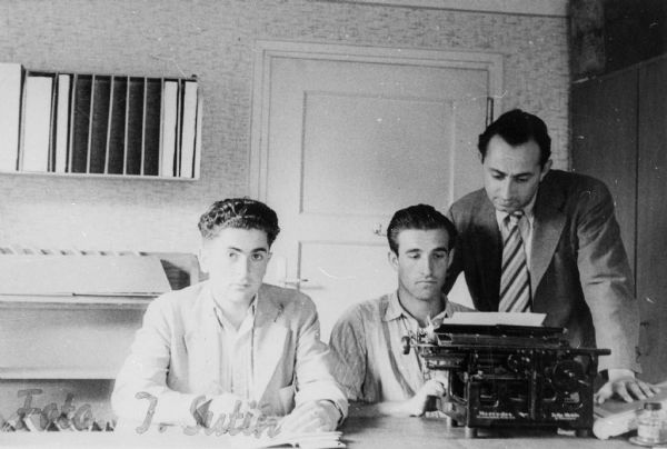 Three male refugees working as clerks in the office of a displaced persons camp; Germany.

Saul Sorrin was interviewed as part of the Wisconsin Survivors of the Holocaust Interviews project. Sorrin, born in New York in 1919, applied in 1940 for a position with the United Nations Relief and Rehabilitation Administration (UNRRA). He worked with Holocaust survivors as a supply officer for UNRAA team 560 at the Displaced Persons camp Neu Freimann Siedlung in Germany and later, at General Dwight D. Eisenhower's recommendation, Sorrin became the Area Director of the International Refugee Organization based at the Wolfratshausen DP camp in Bad Kissingen.

When asked about this image, Sorrin revealed, "These are some of our clerks in one of the camps. I remember this man's name on the right.  He was a welfare worker and his name is Sternberg. And these are two people who in this particular place were keeping documentation on newcomers into the camp."

Interview by Jean Loeb Lettofsky and David Mandel, March 3, 1980.