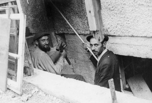 Construction of a mikveh (ritual bath) by religious Jews; Neu Freimann D.P. camp; Munich.<p>Saul Sorrin was interviewed as part of the Wisconsin Survivors of the Holocaust Interviews project. Sorrin, born in New York in 1919, applied in 1940 for a position with the United Nations Relief and Rehabilitation Administration (UNRRA). He worked with Holocaust survivors as a supply officer for UNRAA team 560 at the Displaced Persons camp Neu Freimann Siedlung in Germany and later, at General Dwight D. Eisenhower's recommendation, Sorrin became the Area Director of the International Refugee Organization based at the Wolfratshausen DP camp in Bad Kissingen.</p>When asked about this image, Sorrin revealed, "This is the construction of a mikveh in the Neu Freimann camp. These are two members of a religious community who were building. The man on the left, I remember he was so persistent...  Because we have to get things, you know, we have to get the boiler to heat the water and we had to get kakhl, tiles, and we had to get piping, all of which was impossible to come by in those days.  They got the JDC to put up about three hundred cartons of cigarettes and with three hundred cartons of cigarettes you could get anything in Germany at that time. And that's the way the [tsukhke organizirt ?]. They called it organizing, sort of just made it available to themselves. And I understand that this mikveh which was built was a short swimming pool and is still there in this house in Munich.  We visited there last August. I should have found that picture and brought it back. Building a mikveh."

Interview by Jean Loeb Lettofsky and David Mandel, March 3, 1980.