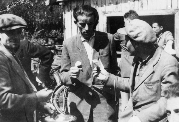 Ice cream being sold outside of a "beer-bar" at a Displaced Persons camp; Germany.

Saul Sorrin was interviewed as part of the Wisconsin Survivors of the Holocaust Interviews project. Sorrin, born in New York in 1919, applied in 1940 for a position with the United Nations Relief and Rehabilitation Administration (UNRRA). He worked with Holocaust survivors as a supply officer for UNRAA team 560 at the Displaced Persons camp Neu Freimann Siedlung in Germany and later, at General Dwight D. Eisenhower's recommendation, Sorrin became the Area Director of the International Refugee Organization based at the Wolfratshausen DP camp in Bad Kissingen.

When asked about this image, Sorrin revealed, "Oh, this is the same beer bar, but here they're selling ice creams outside. You see the ice cream cones? In Polish, ice cream was hawked as lody, which means ice, ice cream. "Lody! Lody!" on the streets. And I think I told you the story that one day several tons of powdered milk disappeared. It was just piling up in the warehouse. Nobody wanted. It disappeared but then it turned into ice cream. I heard later on that that's where our powdered milk went. I wasn't worried about it."

Interview by Jean Loeb Lettofsky and David Mandel, March 3, 1980.