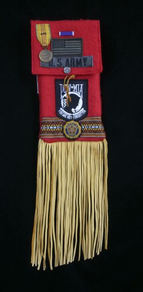 A red, fringed Indian (Native American) pouch with fabric patches that read "U.S. Army" and "POW-MIA".