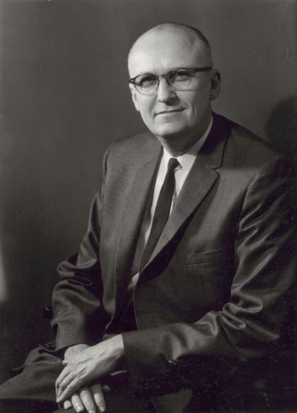 Seated studio portrait of Fred H. Harrington, who was the University of Wisconsin-Madison President beginning in 1962. During his nine-year tenure, Mr. Harrington won national acclaim for elevating the university's academic standing and leading the drive to extend the state university system's campus services to the inner cities. In May 1970, he announced his resignation, citing a lack of support from regents and legislators and sheer fatigue.