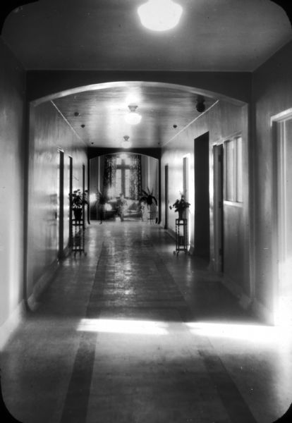 View of a hallway in the recently-constructed Methodist Hospital. There is a man sitting at the end of the hall under the window.