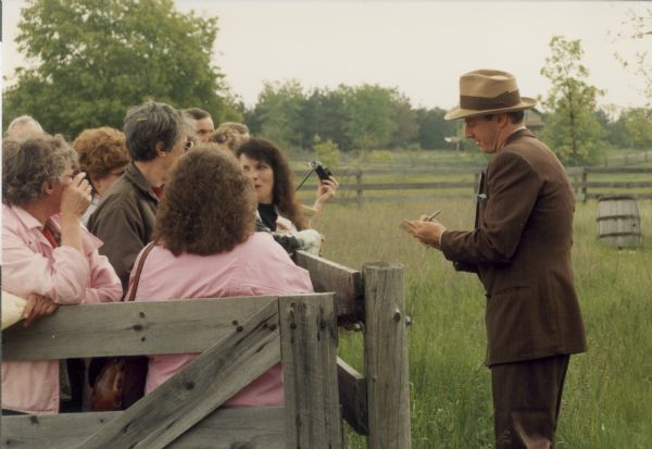 Costumed for the lead role in the made-for-TV movie "Dillinger," actor Mark Harmon signs autographs for some tourists who were visiting Old World Wisconsin, the historic site where some of the picture was filmed.
