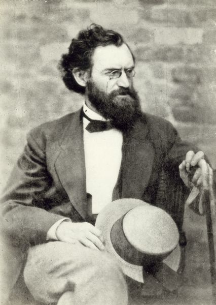 Portrait of Carl Schurz, seated, holding a hat and cane.