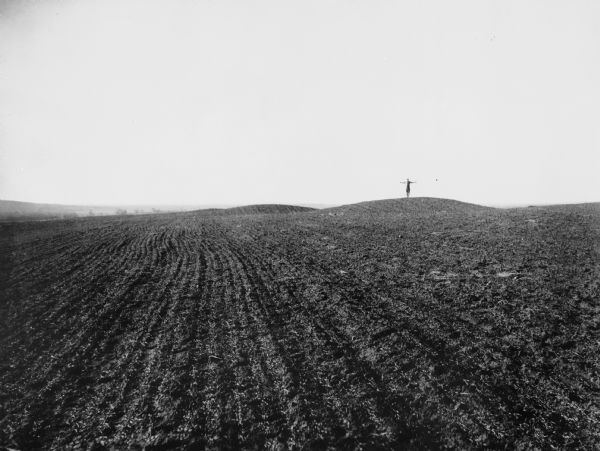 A man in the distance stands on a mound, which is part of a group of mounds near the Fox River. Many artifacts including arrowheads and human bones have been excavated here.