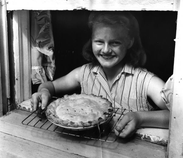 Fourteen-year-old Dorothy Magarich proudly displays her pie that won a blue ribbon at the Wisconsin State Fair.