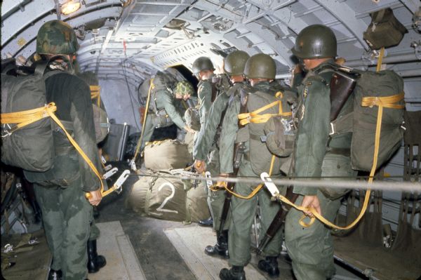 A view of special forces training taken by freelance photographer Dickey Chapelle inside a C-47 transport plane. The photograph shows the preparations for a jump.