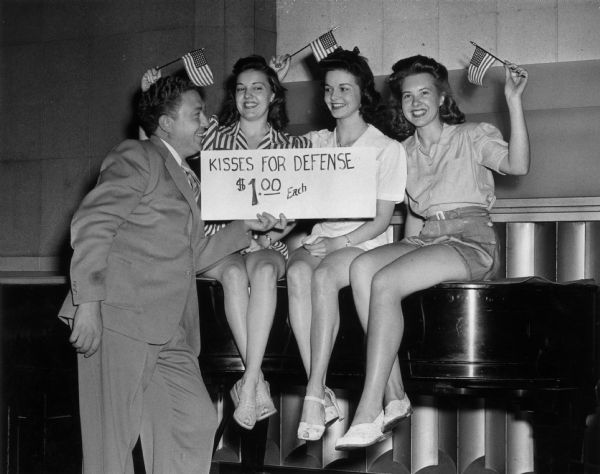 Three pretty receptionists of radio stations WHK-WCLE came forward today with a new idea for defense, which they proposed be put in operation at the forthcoming Festivals of Freedom celebration to be held on the Fourth of July at Cleveland Stadium. 

From left to right are: Carol Decker, 5350 Porter Road, North Olmstead; Elma Kendall, 8615 Euclid Avenue;  Lenore Steppke, 1606 Latchmont Avenue, Lakewood. Shown with them is Dick O'Heren, tenor of WCLE, who is helping promote the idea.