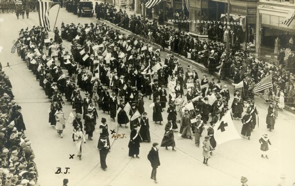 Postcard of men and women marching in Madison, Wisconsin's Loyalty Parade through the streets of the city.