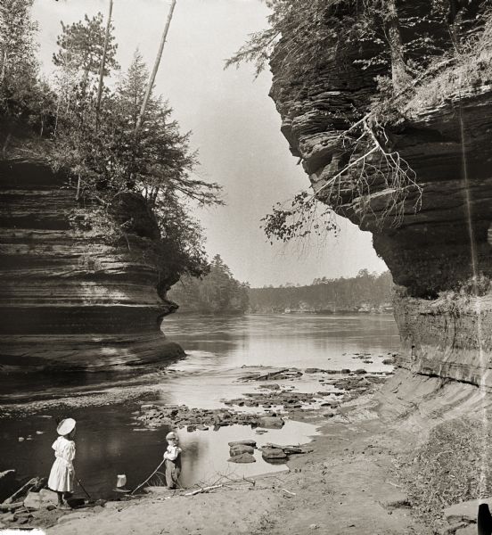 Steamboat Rock, with two children playing at the edge of the river.