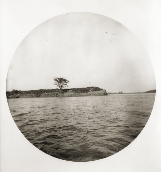 A view at the mouth of the Wabash River of a lone tree on what appears to be a peninsula.