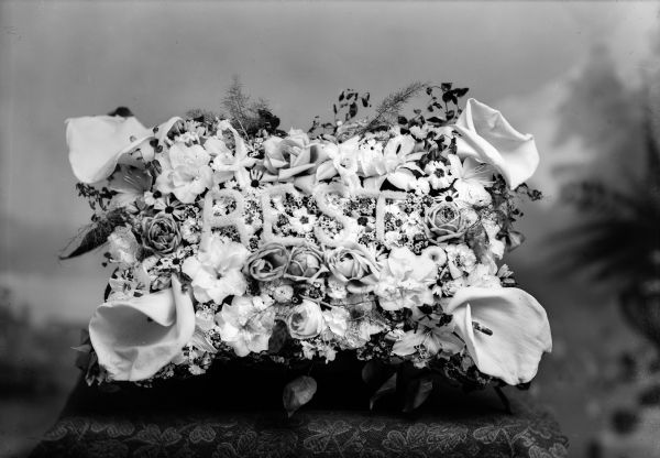 Studio portrait of a flower arrangement that says, "REST".